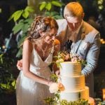 A bride and groom cutting their wedding cake at their reception.