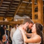 A wedding reception featuring a bride and groom sharing their first dance in a barn.