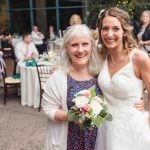 A bride and her mother posing for a photo at a wedding reception.