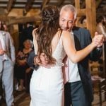 A bride and her father dance at a wedding reception.