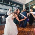 A bride and her bridesmaids having a fun lightsaber battle at the wedding reception.