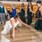 A bride dancing with her bridesmaids at a wedding reception. (Keywords: Reception, Wedding)