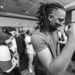 A black and white photo of a man dancing at a wedding reception.