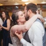 A couple sharing a kiss at their wedding reception.