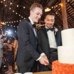 Two men celebrating a wedding reception in a barn.