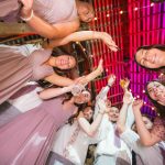 A group of bridesmaids and groomsmen at a wedding reception.