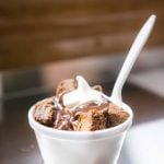 A wedding dessert featuring a bowl of brownies with whipped cream on top.