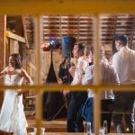 A couple at their wedding reception standing in front of a window in a barn.