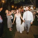 A bride and groom walk away with sparklers at their wedding reception.