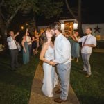 A newlywed couple sharing a kiss during their wedding reception.