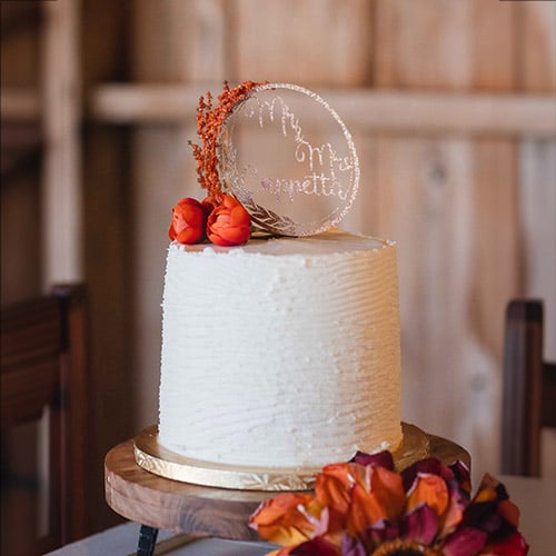 A wedding cake with a pumpkin on top, created by Cakes by Krissy.