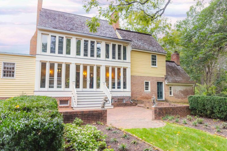 A yellow house perfect for a wedding venue with a large front porch.