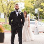 A man in a tuxedo walks down the street towards the Great Room at Savage Mill, where a wedding preceremony is about to take place.