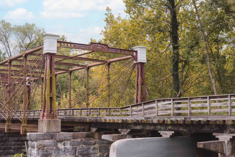 A picturesque old bridge, covered in rust and spanning gracefully over a serene river.