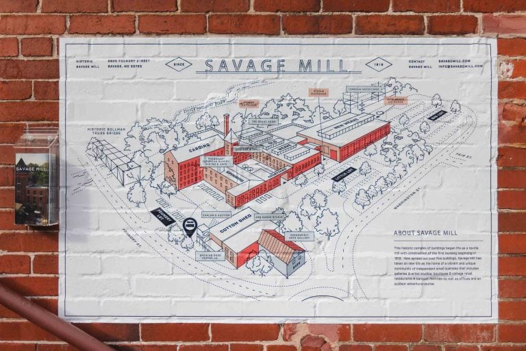 A detailed map of Savage Mill displayed on a brick wall, perfect for planning a wedding.