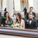 A wedding reception at The Great Room at Savage Mill, with the bride and groom standing in front of a mirror.