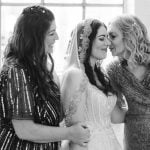 A candid black and white photo of a bride and her bridesmaids at a wedding in Savage Mill.