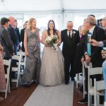 Description: A bride and groom having their wedding ceremony in a tent at Savage Mill.