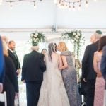 A wedding ceremony at Savage Mill where the bride and groom gracefully walk down the aisle in a beautifully decorated tent.