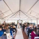 A wedding ceremony at Savage Mill, adorned with string lights.