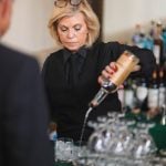 A bartender pouring a drink at a wedding reception.