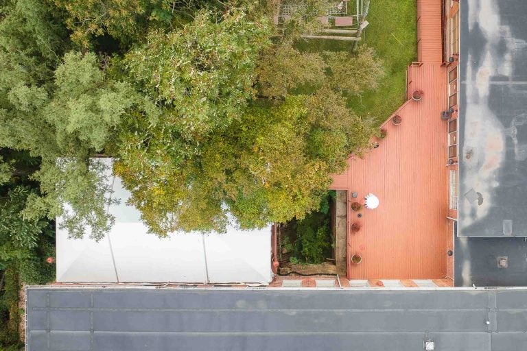 An enchanting aerial view showcasing the picturesque details of a roof nestled amidst lush trees at Savage Mill.