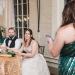 A bride and groom sitting at a table at a wedding reception in Savage Mill.