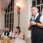 The groom delivering a heartfelt speech at a wedding reception.