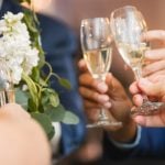 A group of people toasting champagne glasses at a wedding reception.