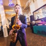 A man playing a saxophone at a wedding reception at Savage Mill.