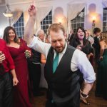 A man is dancing at a wedding reception held at Savage Mill.