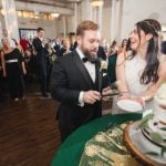 A bride and groom elegantly cutting their wedding cake at the Savage Mill reception.