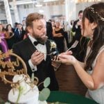 Savage Mill wedding reception featuring a bride and groom feeding each other their wedding cake.