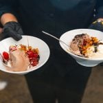 Two waiters at a wedding, holding two bowls of ice cream with exquisite details.