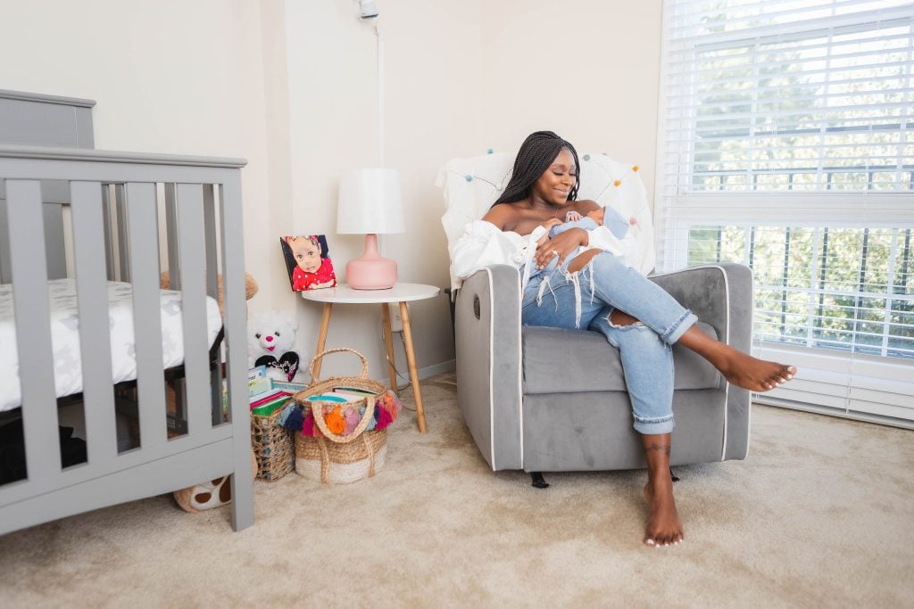 A woman sitting in a chair in a newborn's room.