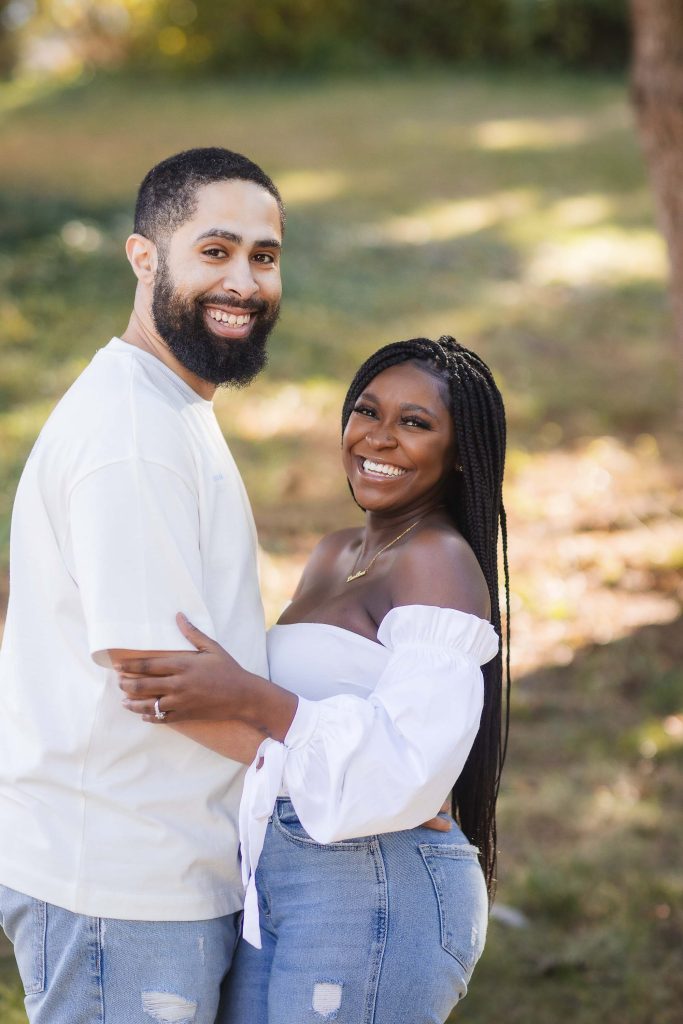 A couple embracing in a park during their engagement session.