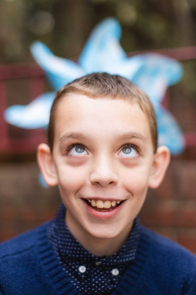 A boy with a blue bow on his head poses for portraits in Downtown Annapolis, alongside his family.