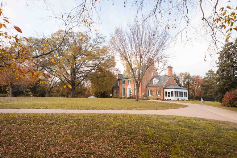 A large brick house is surrounded by trees in Alexandria.