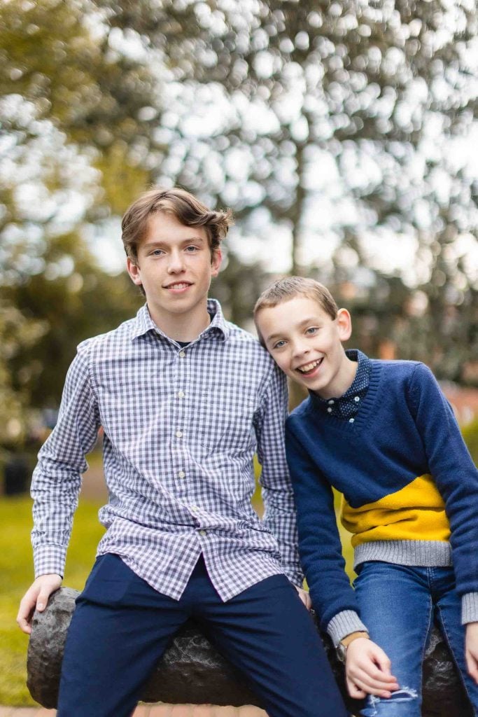 Two boys sitting on a bench in a park in Downtown Annapolis.