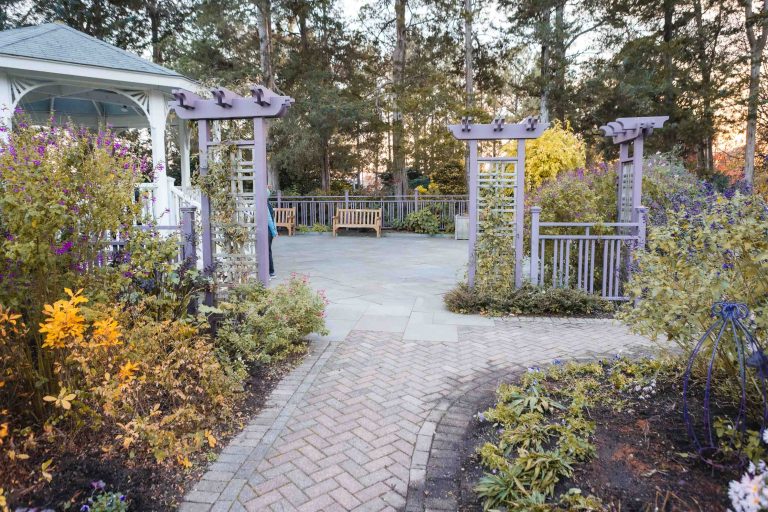 Green Spring Gardens, located in Alexandria, Virginia, features a beautiful garden adorned with a gazebo and bursts of vibrant purple flowers.