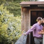 A couple kisses at sunset in front of a wooden shed at Patuxent Research Refuge in Maryland.