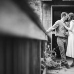 A black and white photo of a couple kissing on a wooden bridge at Patuxent Research Refuge in Maryland. [Engagement Photos]