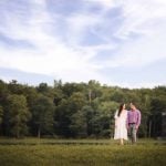 A Maryland couple sharing a tender moment during their engagement photoshoot at sunset near a serene lake.