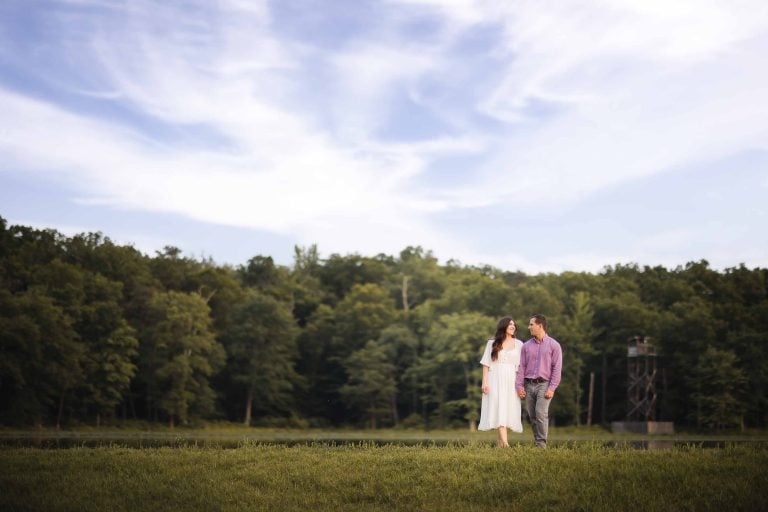 A Maryland couple sharing a tender moment during their engagement photoshoot at sunset near a serene lake.