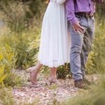 A man and woman embrace in a field of tall grass at sunset in Maryland's Patuxent Research Refuge.