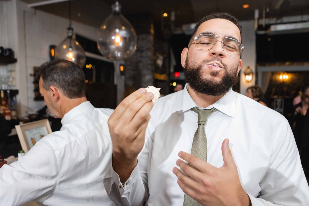 A man is enjoying a piece of cake at a wedding reception at Blackwall Barn & Lodge.