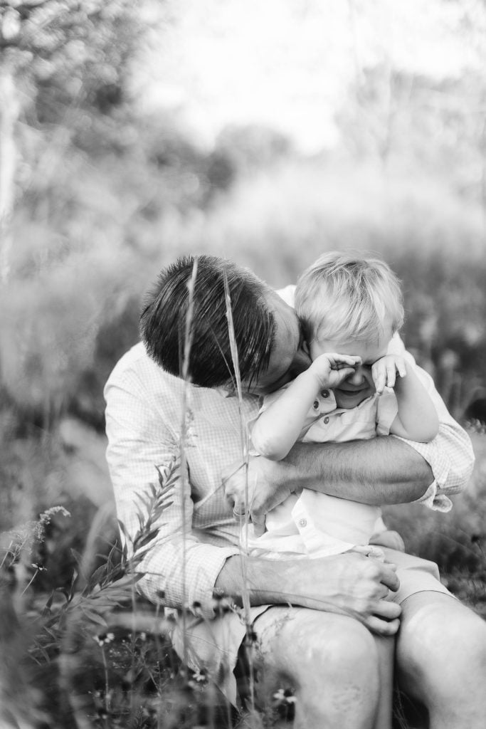 A black and white photo of a man kissing his son in Quiet Waters Park.