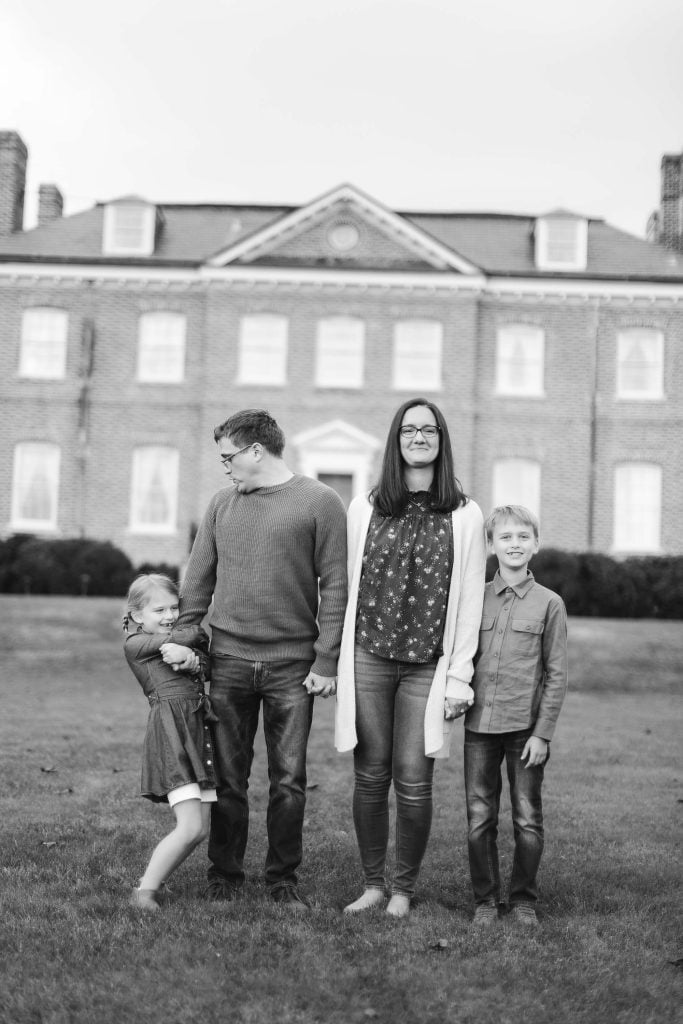 A black and white photo of a family posing in front of Belair Mansion.