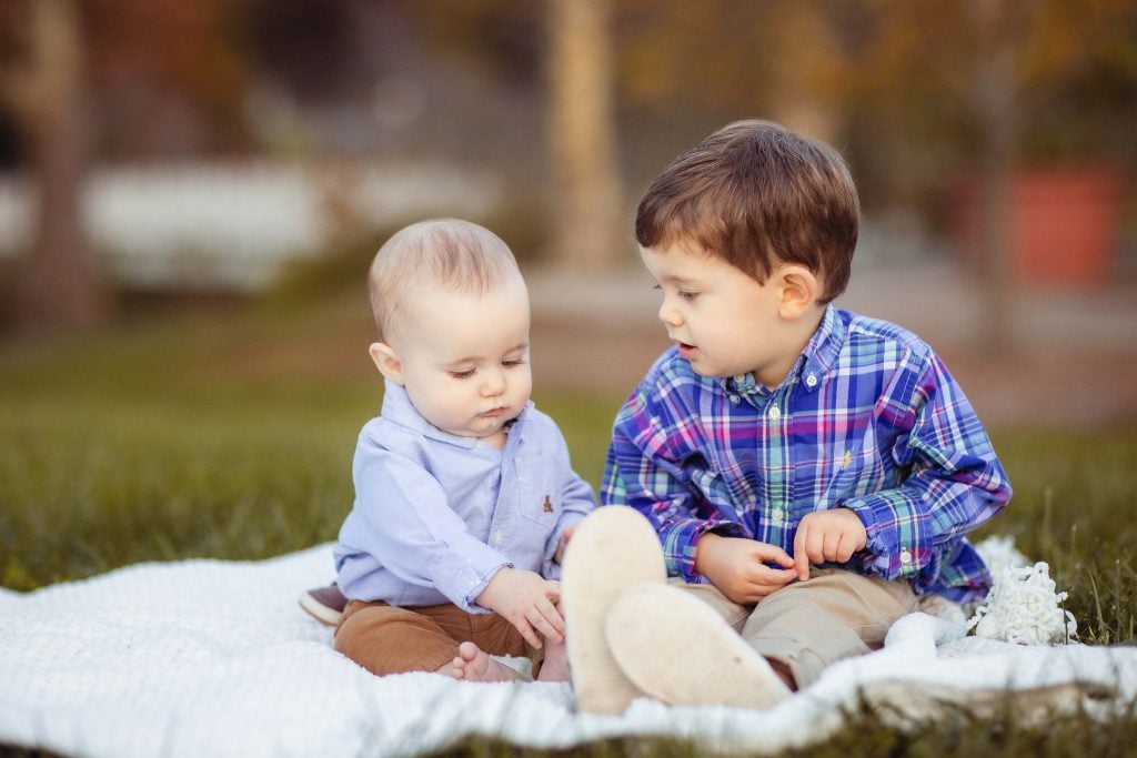 Two boys sitting on a blanket at Quiet Waters Park.