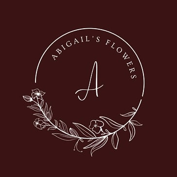 A business logo for Leesburg Virginia florist, Abigail's Flowers, which features a white floral circle surrounding a stylized letter "A" against a dark maroon background.